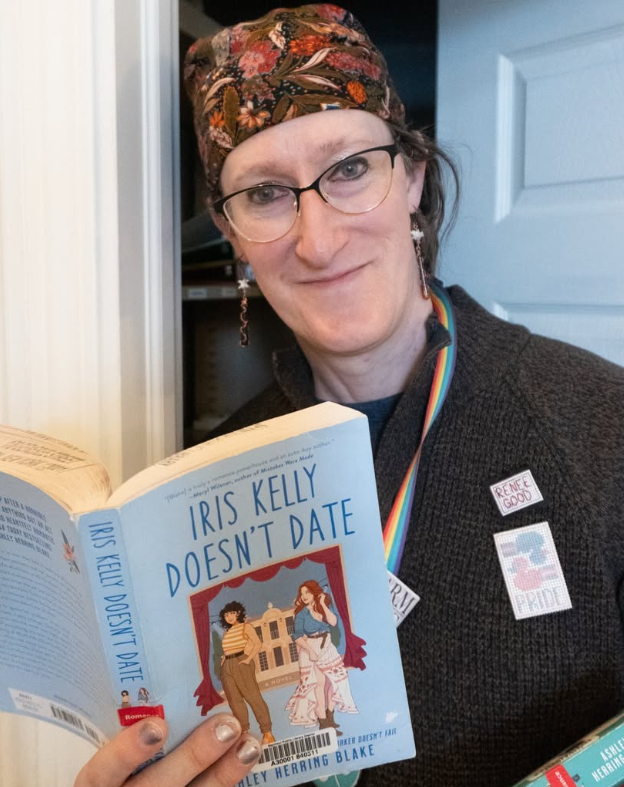 A Seymour Library staff member poses with a book for Library Shelfie Day