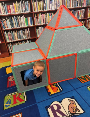 child playing with super space tiles at the library