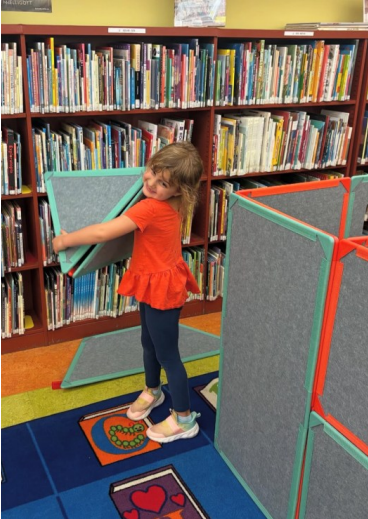 child playing with super space tiles at the library