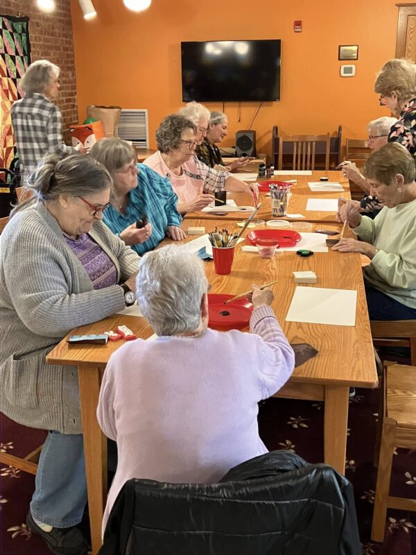 older adults making a craft at the library